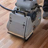 Close-up of a floor sander used during hardwood floor installation and repair.